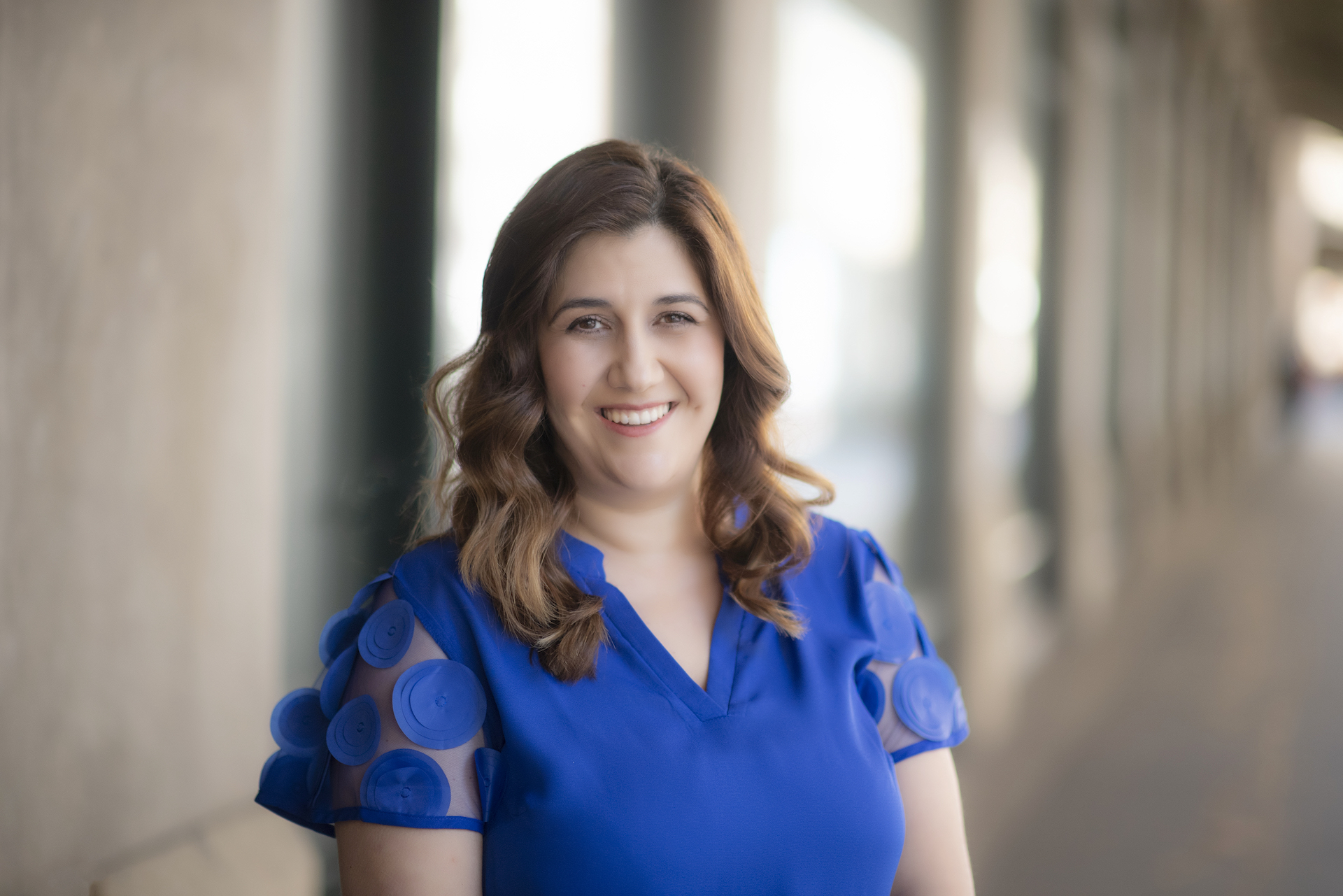 A smiling woman in a blue shirt.